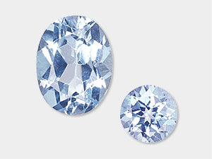 Two faceted blue topaz gemstones, one oval and one round, with light blue sparkle